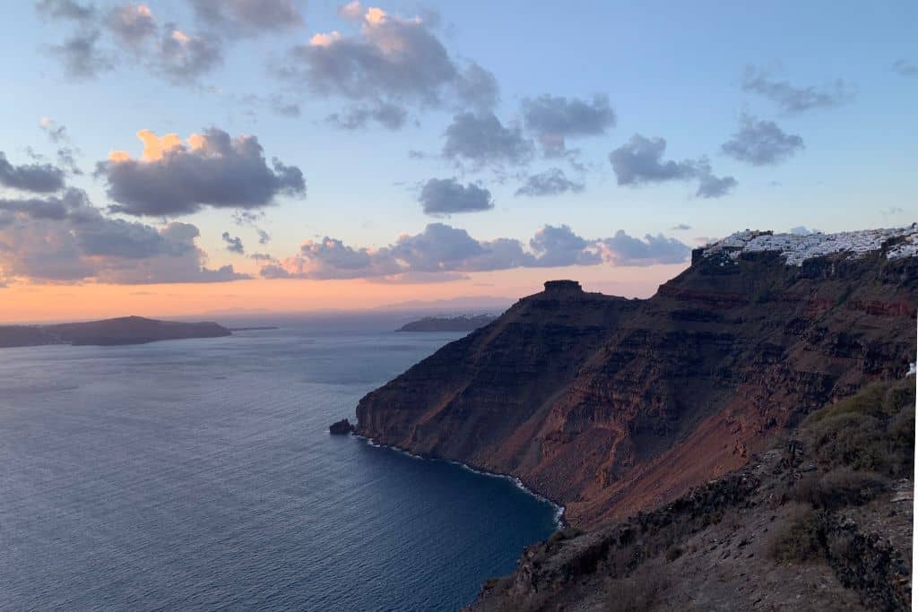 Sunset in Fira, Santorini. The stunning scenery of the caldera makes Fira one of the best places to take a flying dress photo shoot on the island.